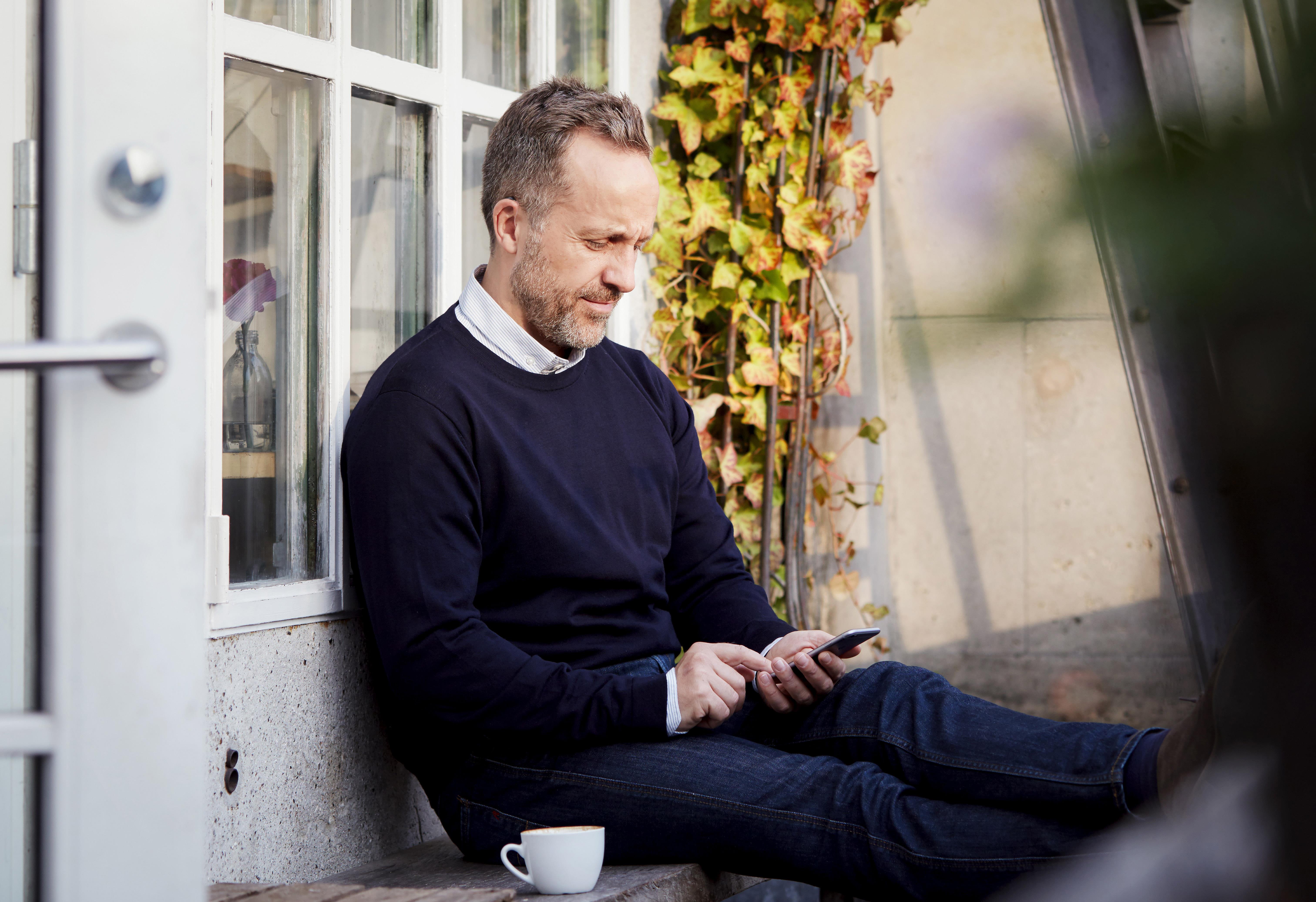 Hombre relajante y usando la aplicación ReSound Relief.