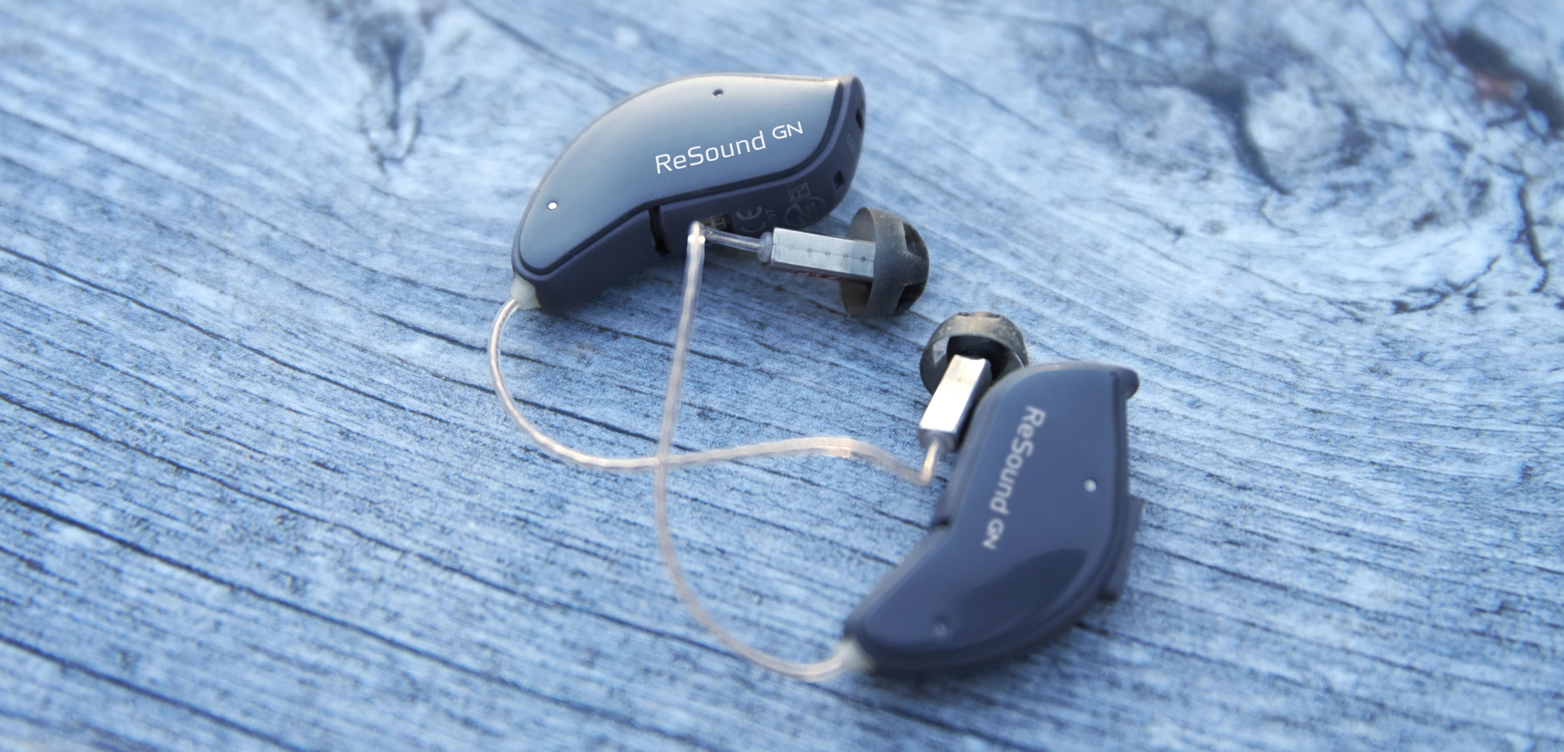 Small pair of ReSound hearing aids on a table. 