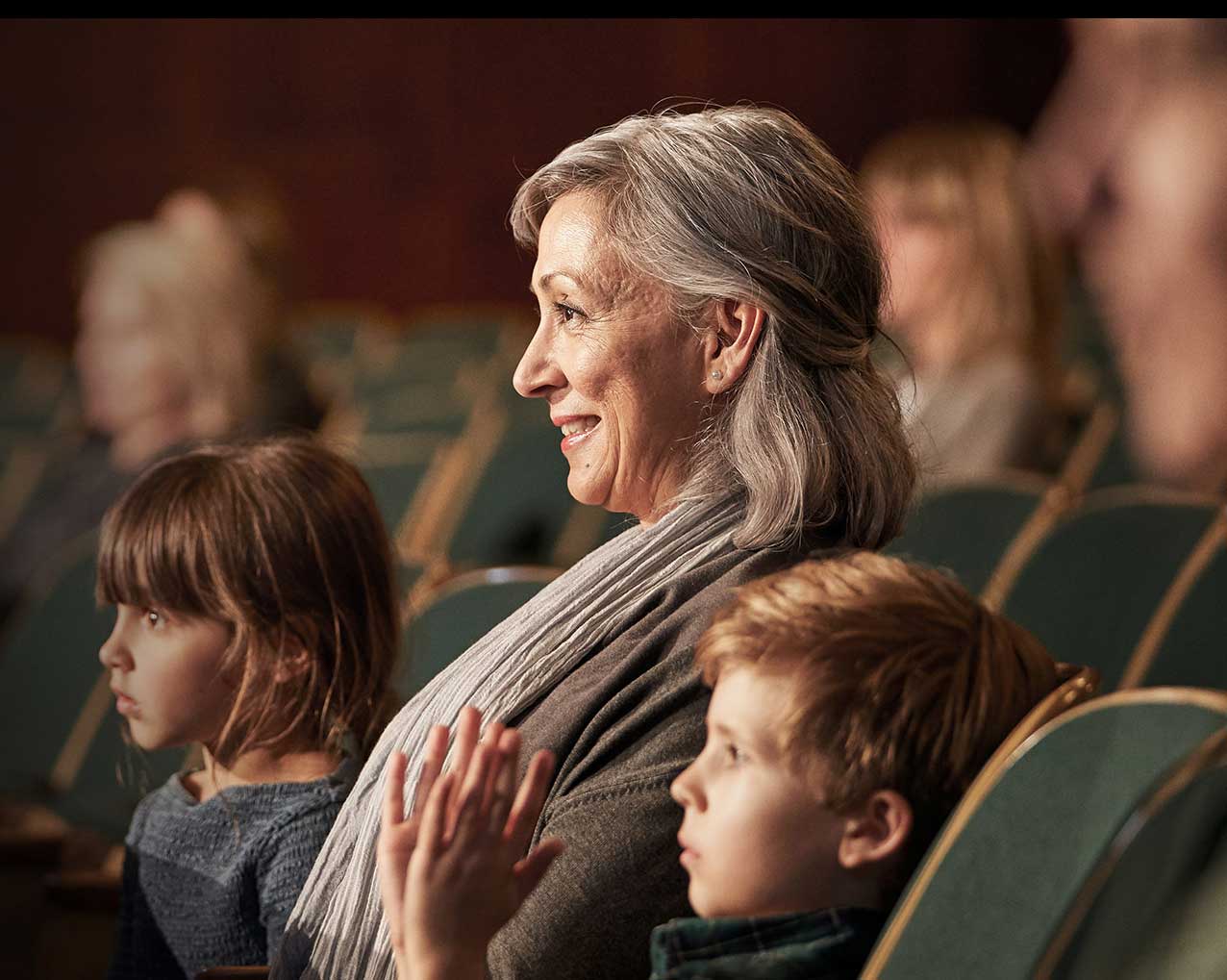 Woman wearing LiNX Quattro hearing aids enjoying life with grandkids 